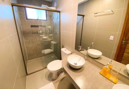 a bathroom with a toilet and a sink and a shower at Pousada Baobá in Jericoacoara