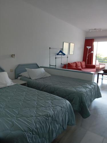 a hotel room with two beds and a couch at Club Atlantis studio 160 - Playa de Las Americas in Adeje