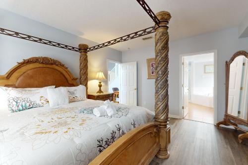 a bedroom with a large bed with a wooden frame at Paradise Villa in Davenport