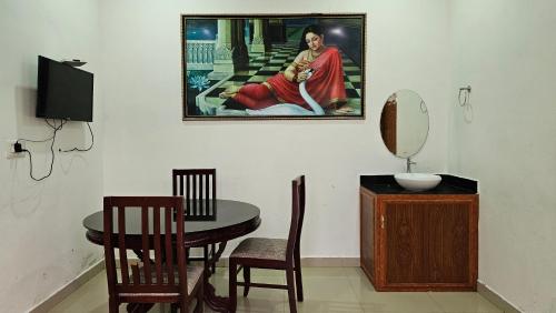 a dining room with a table and a painting on the wall at The Star Resorts in Vagamon