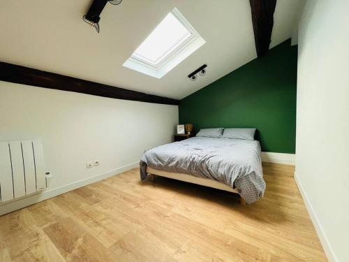 um quarto com uma cama e uma parede verde em Le Faubourg ! Appartement Type 3 em Nancy