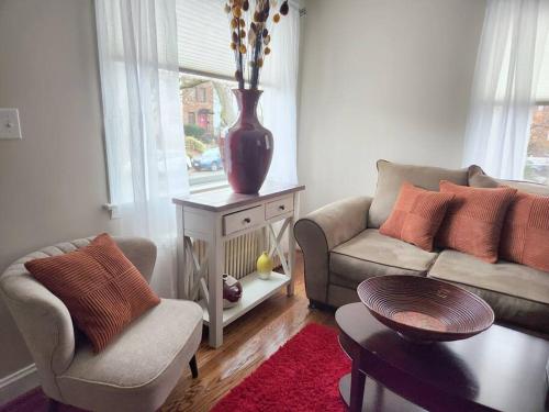 a living room with a couch and a vase on a table at Daisy's Heavenly Townhome in Alexandria