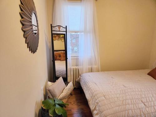 a bedroom with a mirror and a bed and a window at Daisy's Heavenly Townhome in Alexandria