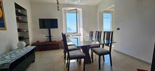 une salle à manger avec une table et des chaises en verre dans l'établissement Finestre sul mare, à Sori