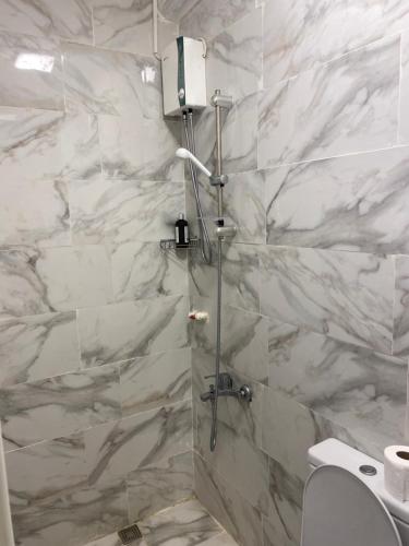 La salle de bains est pourvue d'une douche et de murs en marbre blanc. dans l'établissement yenikapı hotel, à Istanbul