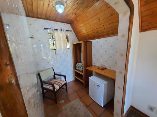 a room with a desk and a chair in a room at Recanto das Hortencias Hotel in Monte Verde