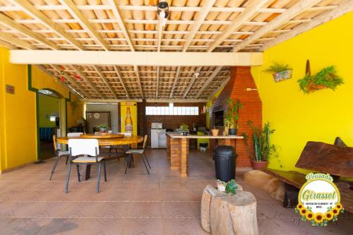 ein Esszimmer mit gelben Wänden sowie einem Tisch und Stühlen in der Unterkunft Pousada Girassol in Chapada dos Guimarães