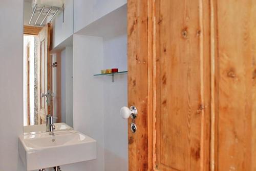 baño con lavabo y puerta de madera en PEN-ARTS apartment- PRINCIPE REAL garden - BAIRRO ALTO, en Lisboa