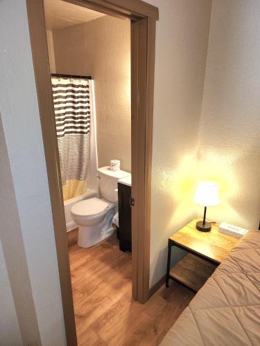 a bathroom with a toilet and a bed and a table at Black Forest Lodge in Big Bear Lake