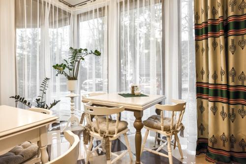 jadalnia ze stołem, krzesłami i oknami w obiekcie Willa Biały Domek w Zakopanem
