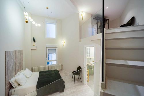 a small bedroom with a bed and a staircase at Espacio Colmenares in Valladolid