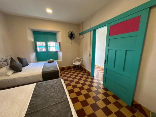 a bedroom with a bed and a green door at CASA HOTEL LAS HORTENSIAS in Jardin