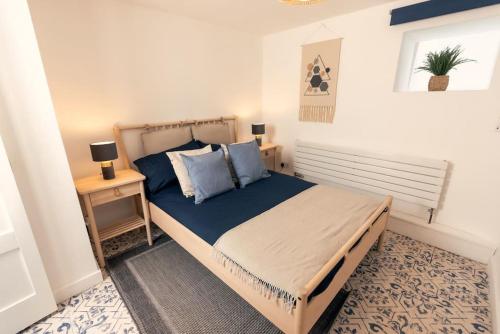 a bedroom with a large bed with blue pillows at Cosy hillside cottage in Great Malvern