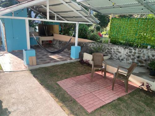 un patio con 2 sillas y una manguera en Cabaña Don Chacon, en Paso Ancho