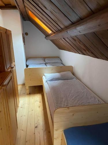 two beds in a small room with a wooden ceiling at Ferienhaus Werkstattl Rassis Feriendorf Donnersbachwald in Donnersbachwald