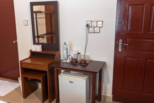 a bathroom with a vanity with a table and a mirror at Captal Beach Villa in Mathiveri
