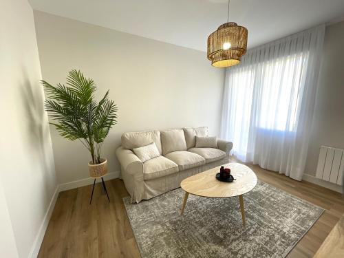 sala de estar con sofá y mesa en ByAndreea Apartaments EtxeBat, en Guernica y Luno