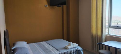 a hospital room with a bed and a window at HOSTAL LLAUT * * in Moquegua