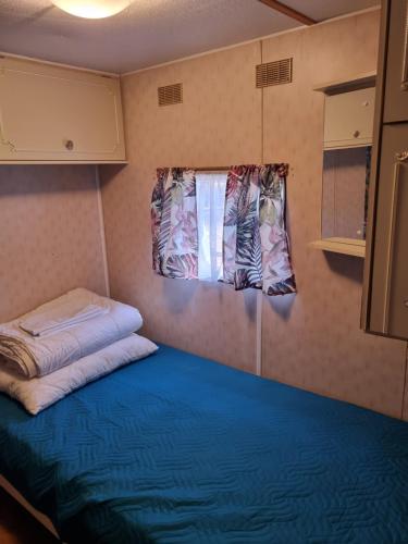 um pequeno quarto com uma cama e uma janela em Wodnik em Pisz
