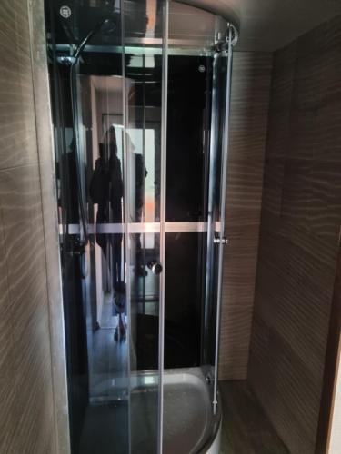 a shower with a glass door in a bathroom at Wodnik in Pisz