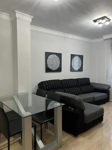 a living room with a couch and a glass table at Apartamento La Muralla II in Baena