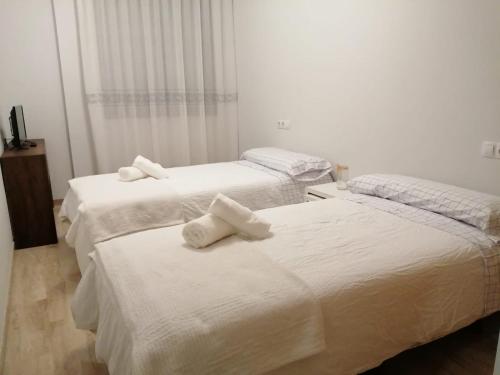 duas camas num quarto de hotel com toalhas em Apartamento La Muralla II em Baena
