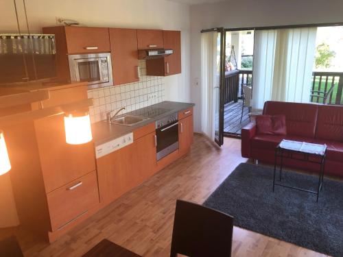 a kitchen and living room with a red couch at WOHNEN by LIZZY in Wagrain