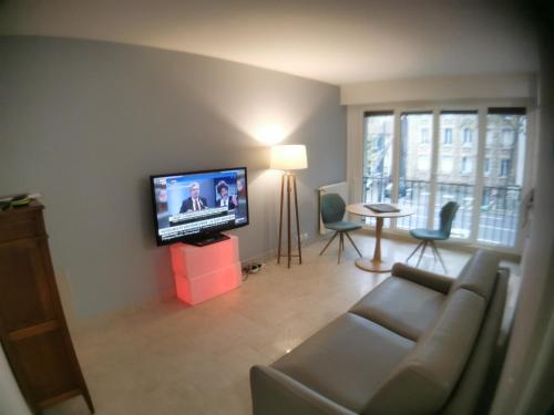 a living room with a couch and a flat screen tv at Studio Chaville in Chaville