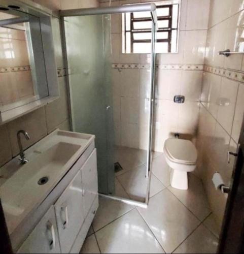 a bathroom with a toilet and a shower and a sink at Pousada AME in Caxias do Sul