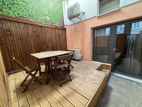 a wooden deck with a table and chairs on a building at Casa Hotel in Aix-en-Provence