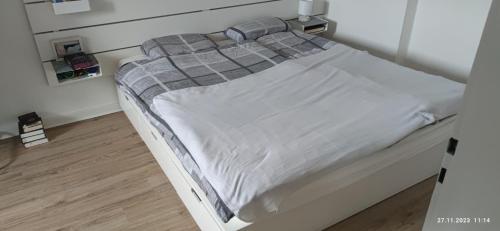 - un lit blanc avec une couverture tressée dans l'établissement Stadtmitte List, à Hanovre