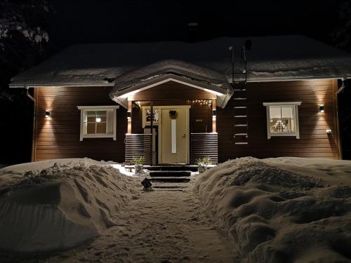 a house is covered in snow at night at Villa Havu holiday home in Pyhä/Lapland in Pyhätunturi