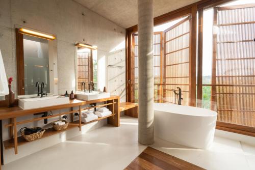 Un baño con dos lavabos y una gran ventana. en Resende Villa, en Itacaré