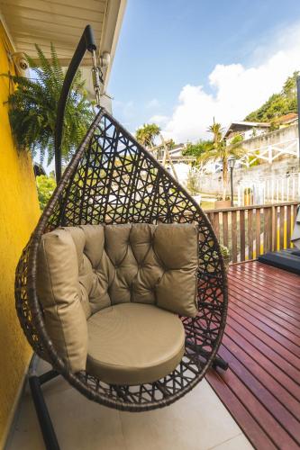 a wicker swing chair on a porch at Pousada Geada de Campos in Campos do Jordão