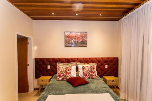 a bedroom with a large bed with two pillows at Pousada Geada de Campos in Campos do Jordão