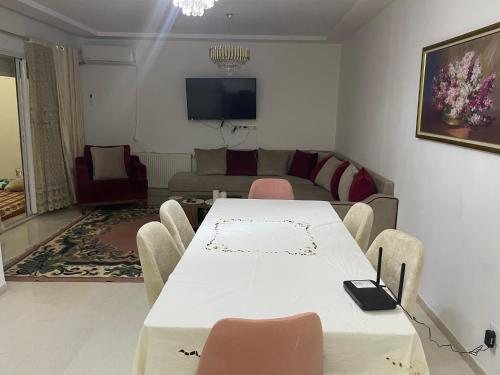 a living room with a white table and chairs at Molk in Manūbah