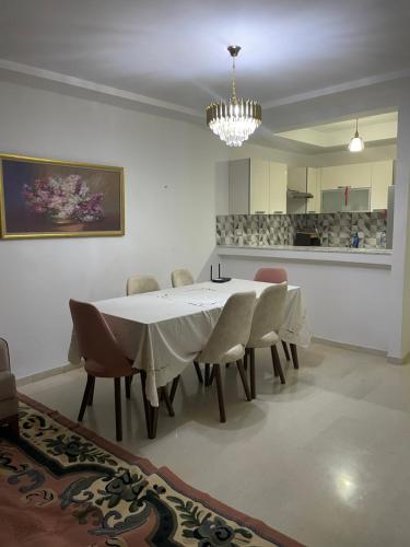une salle à manger avec une table et des chaises blanches dans l'établissement Molk, à Manūbah