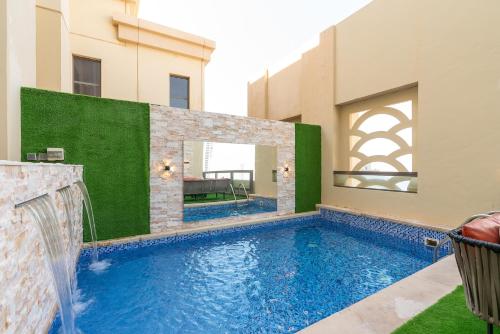 ELAN RIMAL SADAF Suites في دبي: مسبح مع شلال في مبنى