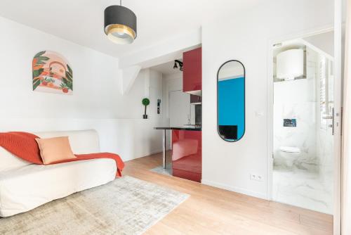 un salon avec un canapé et un miroir dans l'établissement Nets Inn Apartments - La Villette, à Paris