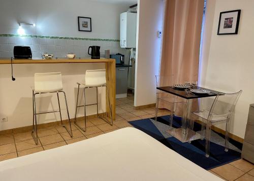- une cuisine avec une table et des chaises dans la chambre dans l'établissement Appartement le Paul Bert Auxerre Les Quais 2 personnes, à Auxerre
