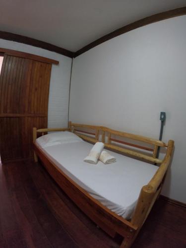 a bedroom with a bed with two towels on it at Morada da Xica in Guarda do Embaú