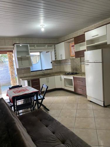 a kitchen with a couch and a table and a refrigerator at Casa da Cris in Penha