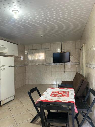 a kitchen with a table and a refrigerator at Casa da Cris in Penha