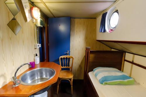 a small bathroom with a sink and a bed at Intersail Hostel - Avontuur in Amsterdam