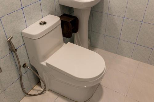 a white toilet in a bathroom with a sink at Captal Beach Villa in Mathiveri