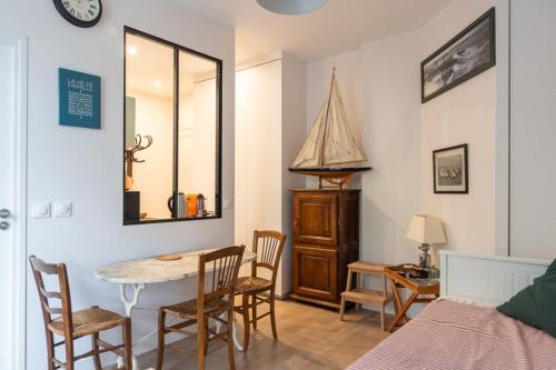 une chambre avec un lit, une table et des chaises dans l'établissement Bright apartment close to the Seine river, à Boulogne-Billancourt