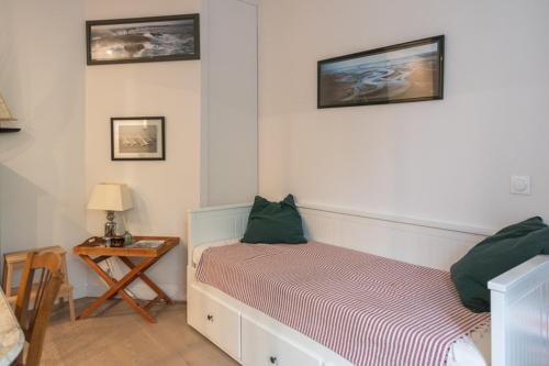 une chambre avec un lit et une table avec une lampe dans l'établissement Bright apartment close to the Seine river, à Boulogne-Billancourt