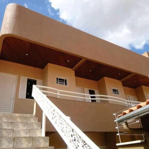 a house with a staircase in front of it at Pousada Luziânia - Conforto no Centro da Cidade in Luziânia