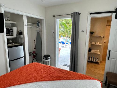 a bedroom with a bed and a kitchen with a sliding glass door at The Agustin Guesthouse - Men Only Clothing Optional in Fort Lauderdale