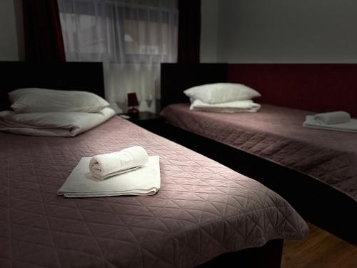 two beds with towels on them in a room at Casa Lupascu in Vatra Dornei